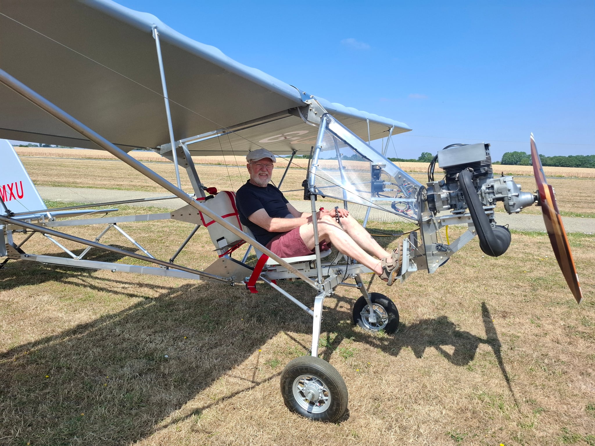 John Riley seated in his newly completed Affordaplane on a grass field